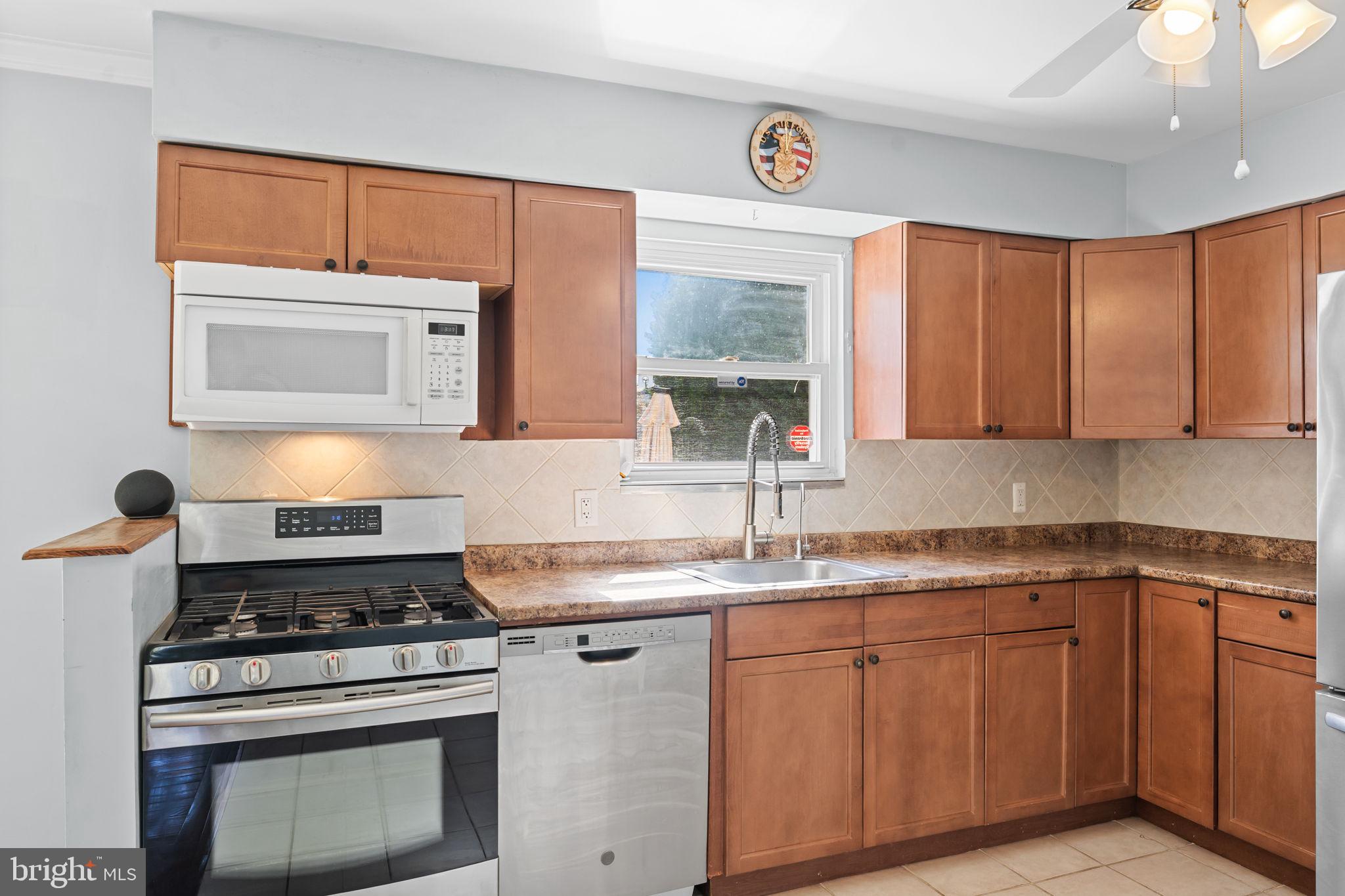 418 Harrison Street Riverside, NJ 08075 - Photo 9 of 29 a kitchen with granite countertop a stove sink and cabinets