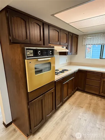 a kitchen with wooden cabinets stainless steel appliances and a sink