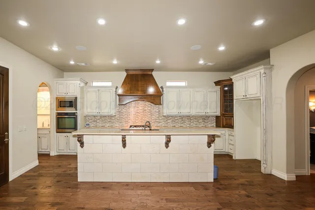 a kitchen with granite countertop white cabinets and white appliances
