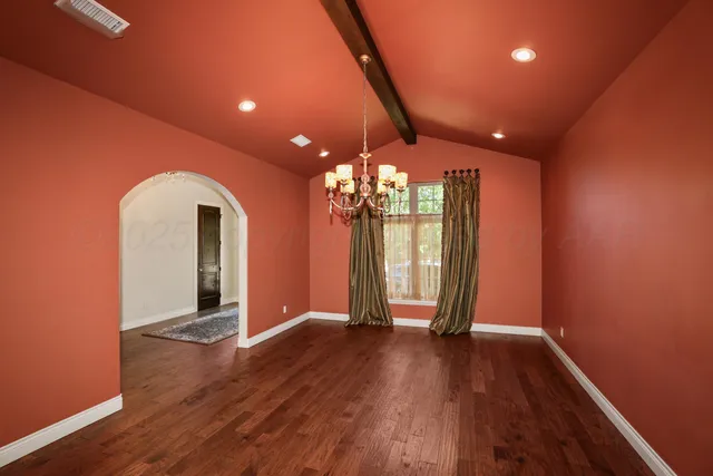 a view of empty room with wooden floor and fireplace