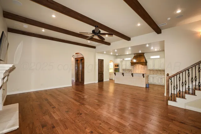 a large kitchen with stainless steel appliances kitchen island granite countertop a refrigerator and a sink