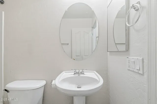 a bathroom with a sink and mirror with toilet