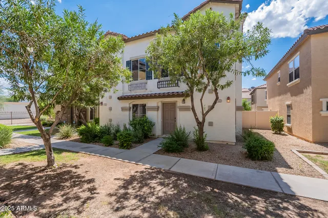 a front view of a house with a yard and tree s