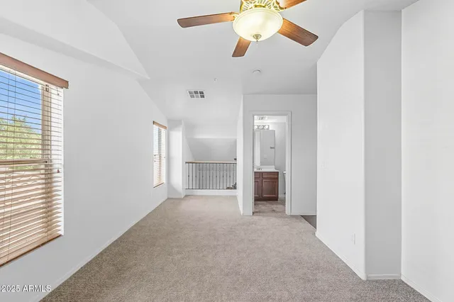 an empty room with fan and windows