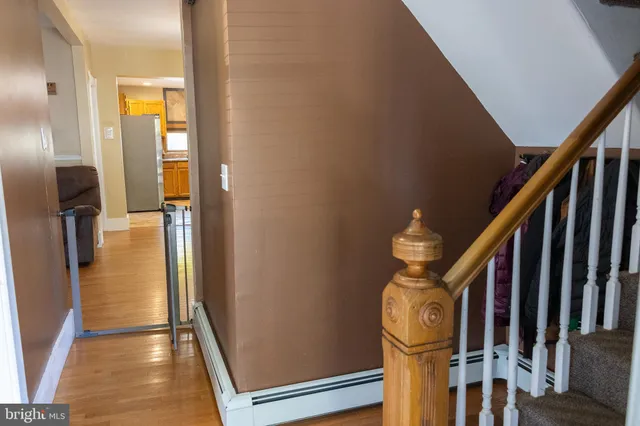 a view of a hallway with wooden floor and staircase