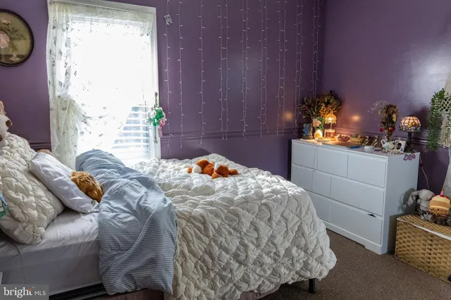 a bed sitting in a bedroom next to a window