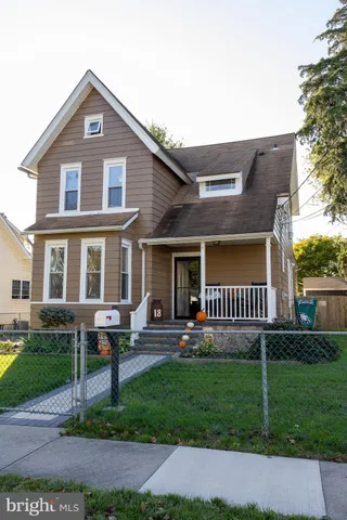 a front view of a house with a yard and potted plants