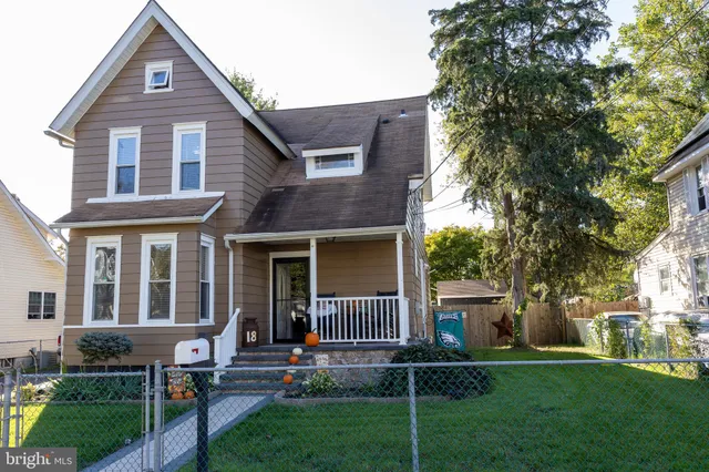 a front view of a house with garden and trees