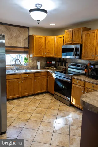 a kitchen with stainless steel appliances granite countertop a stove sink and cabinets