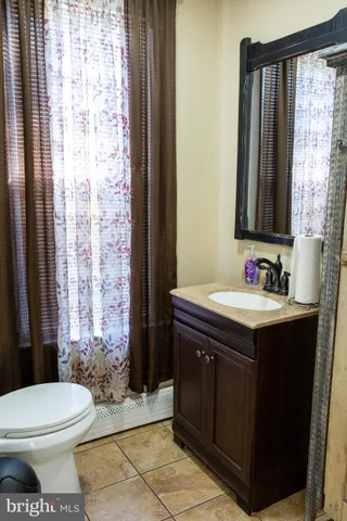 a bathroom with a sink vanity mirror and toilet