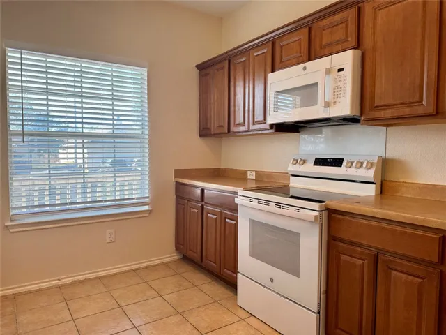a kitchen with stainless steel appliances granite countertop white cabinets sink and a granite counter top