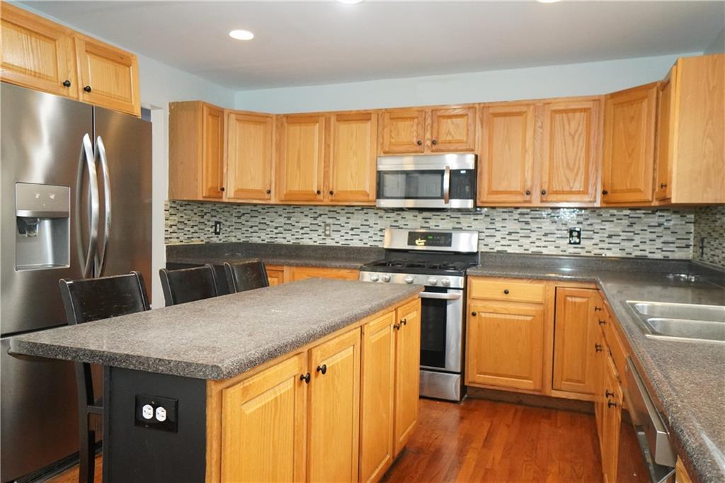 728 Mercer Street Pittsburgh, PA 15219 - Photo 9 of 27 a kitchen with stainless steel appliances granite countertop a sink stove refrigerator and cabinets