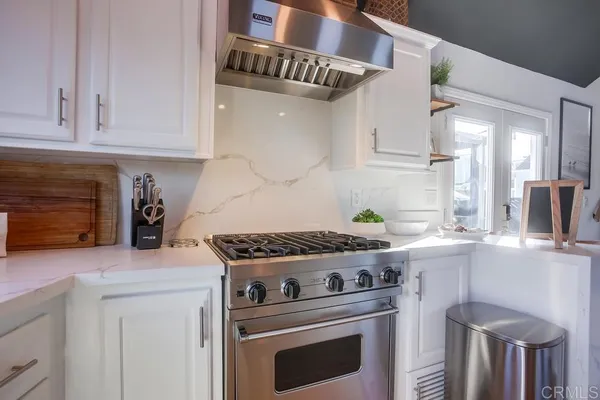 a bedroom with bed and a washing machine with the side of it