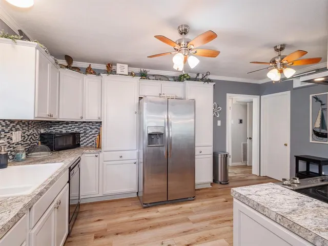 a kitchen with stainless steel appliances granite countertop a refrigerator a sink and dishwasher