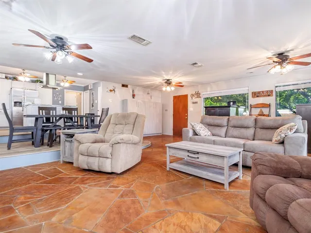 a living room with furniture a chandelier and a dining table