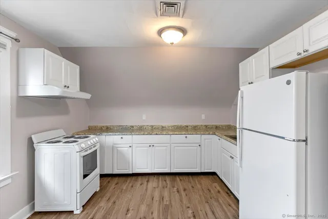 a kitchen with white cabinets and white appliances