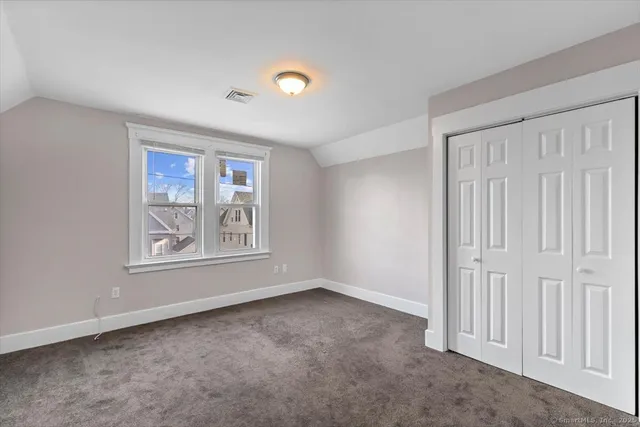 an empty room with windows and closet