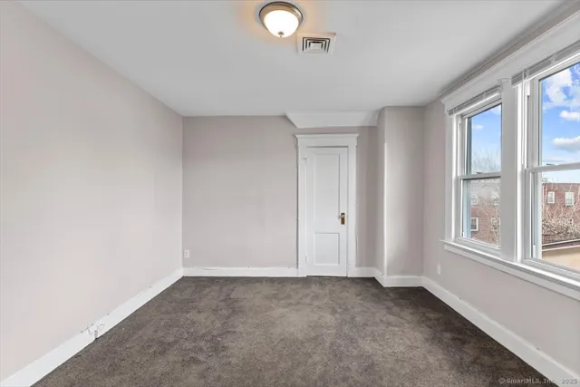 an empty room with windows and closet