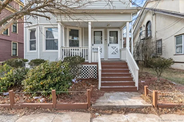 a view of a house with a small yard and wooden floor and fence