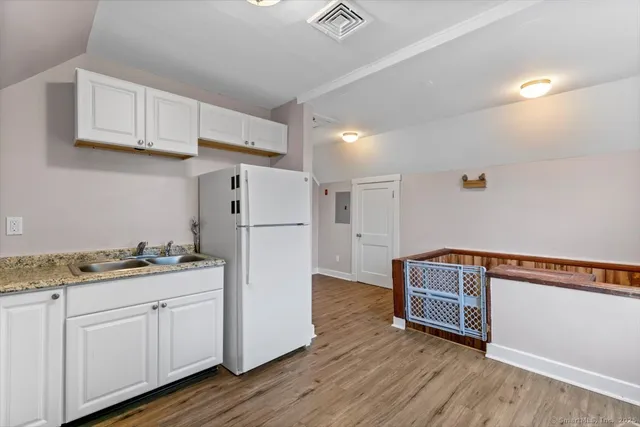 a kitchen with cabinets and wooden floor