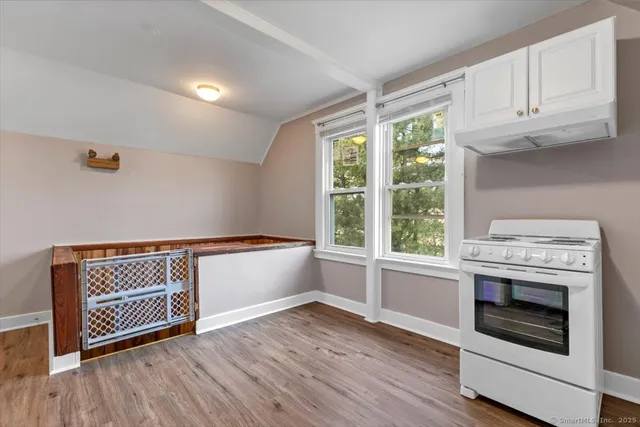 a kitchen with granite countertop wooden floors and white appliances