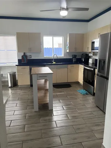a kitchen with a table chairs and a floor to ceiling window