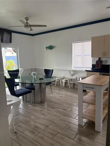 a view of kitchen with refrigerator and wooden floor