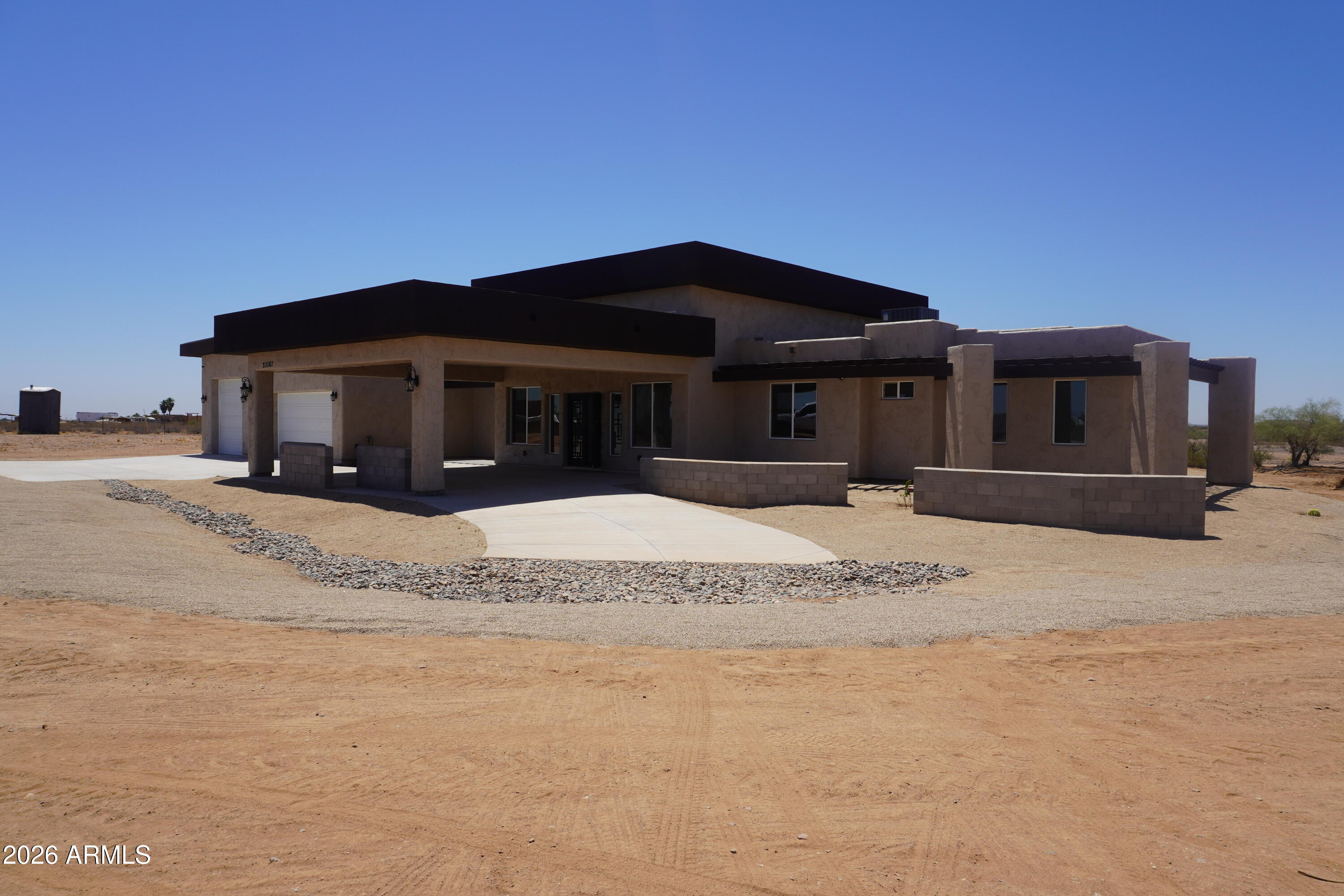 23167 West Montgomery Road Wittmann, AZ 85361 - Photo 2 of 44 a front view of a house with a outdoor space