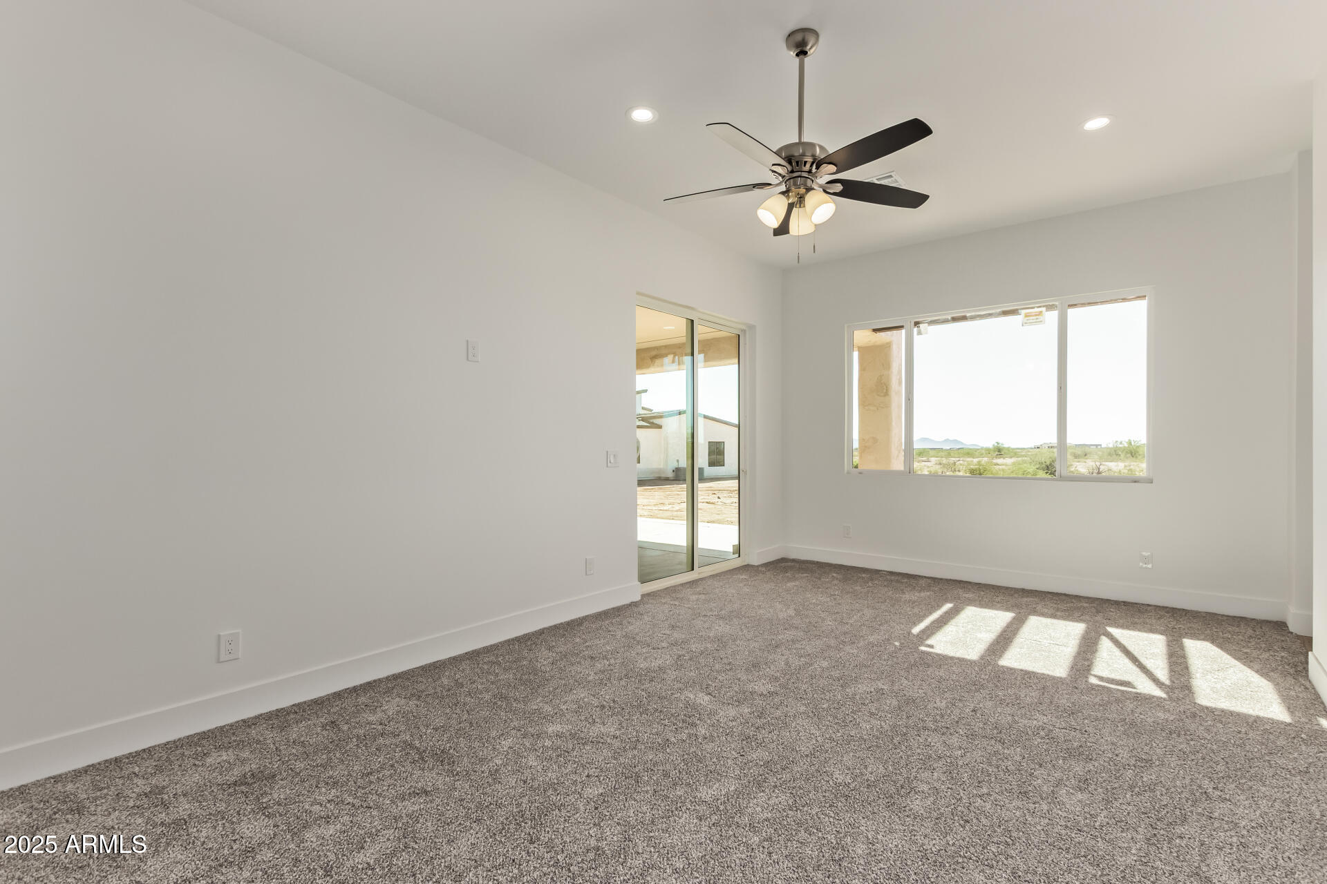 23167 West Montgomery Road Wittmann, AZ 85361 - Photo 21 of 44 an empty room with windows and fan