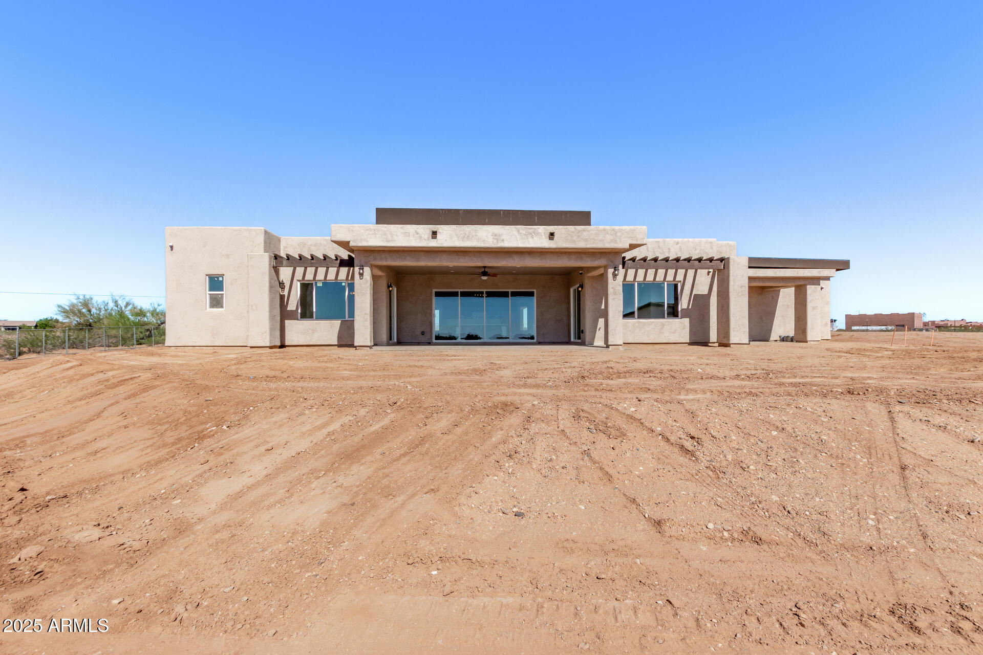 23167 West Montgomery Road Wittmann, AZ 85361 - Photo 7 of 44 a view of a white house with a outdoor space