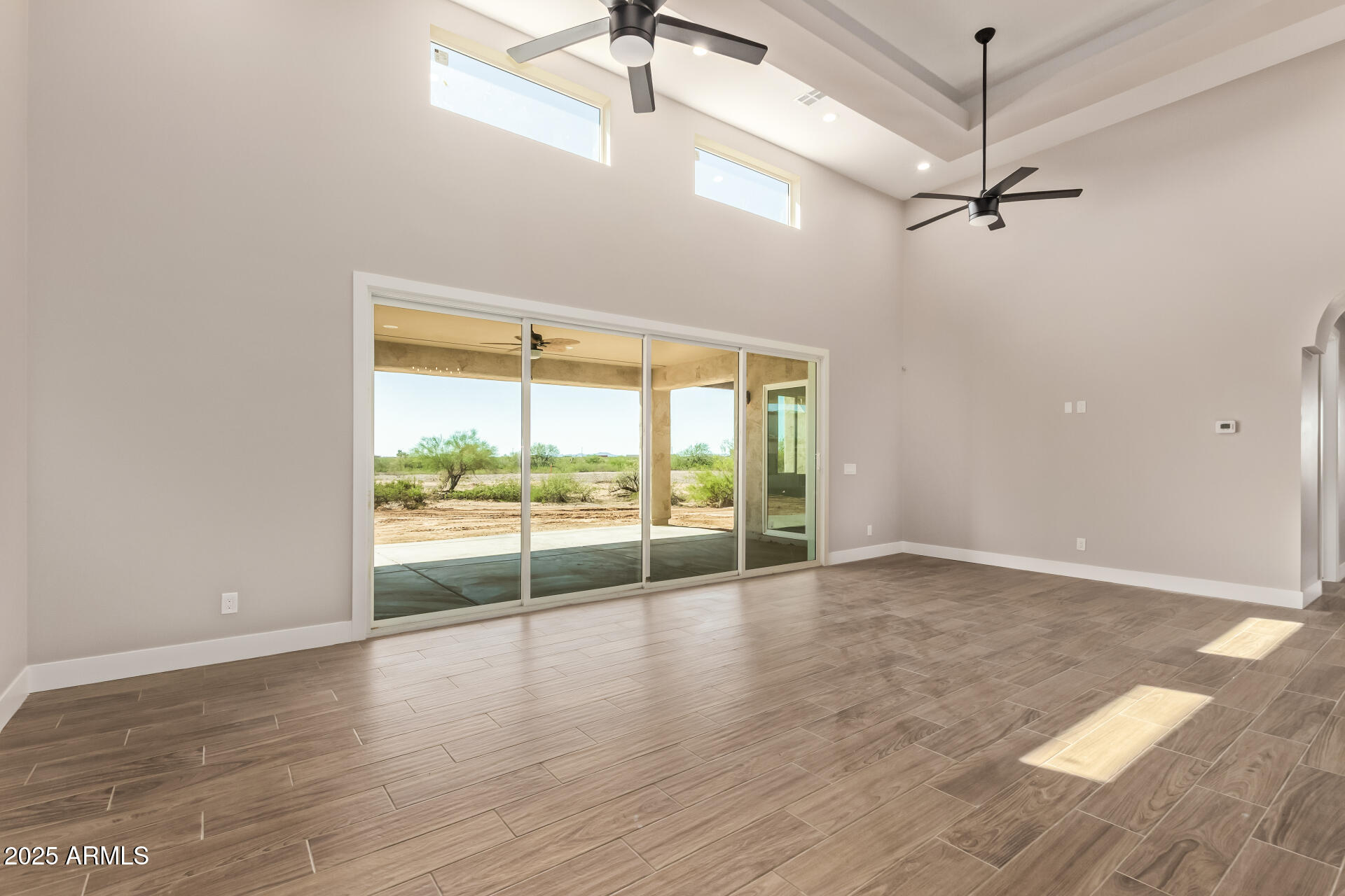 23167 West Montgomery Road Wittmann, AZ 85361 - Photo 9 of 44 an empty room with wooden floor and windows