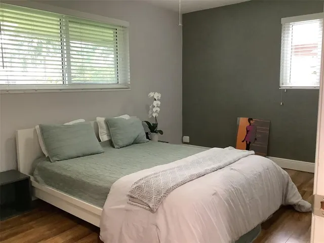 a bedroom with a bed and wooden floor
