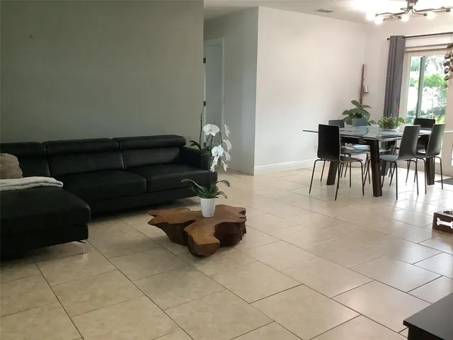 a living room with patio furniture and a dining table