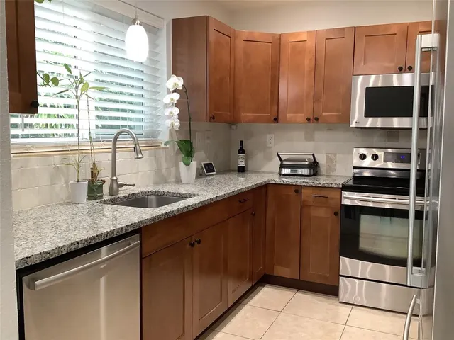 a kitchen with stainless steel appliances granite countertop a sink stove and microwave