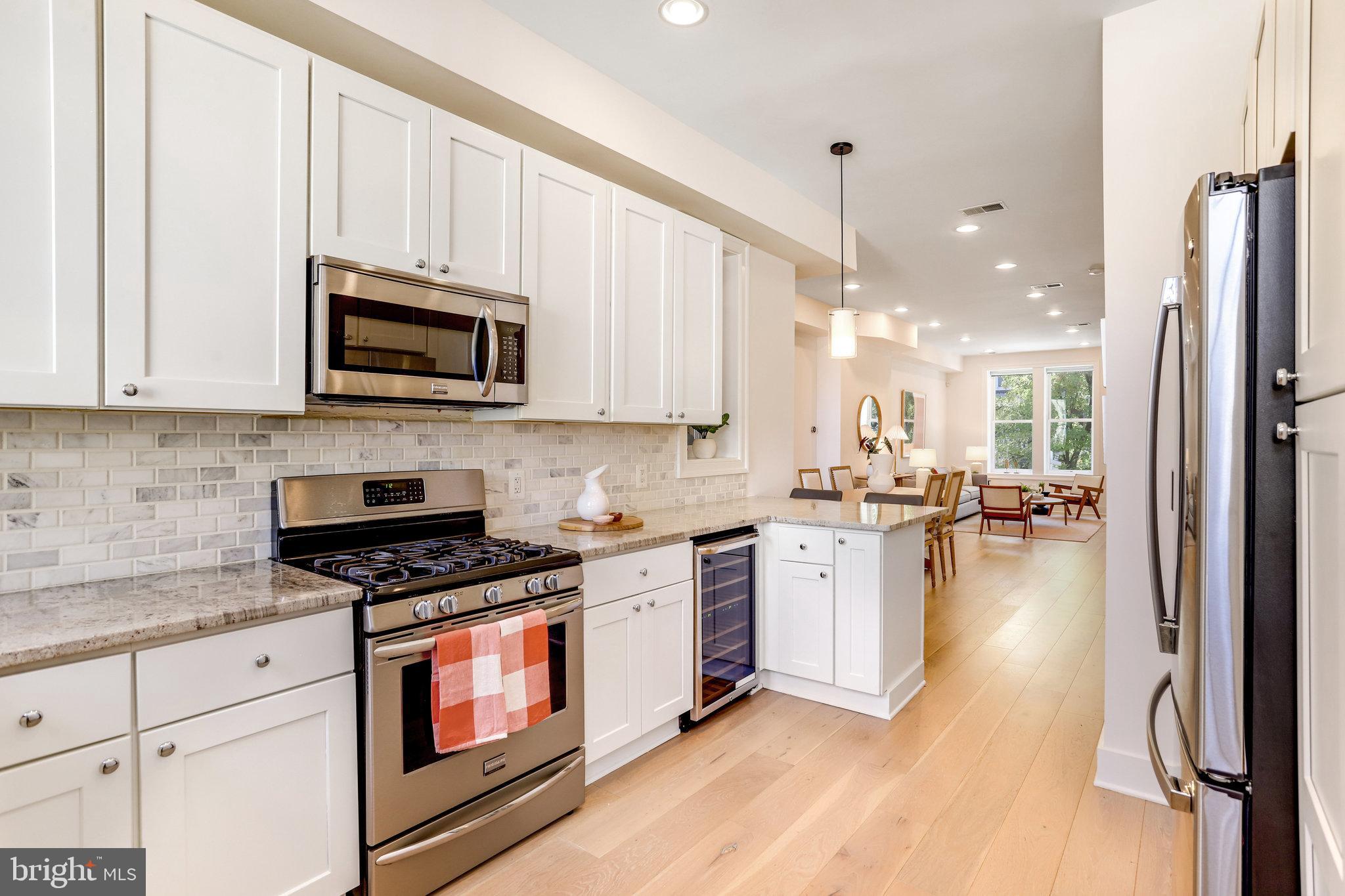 1304 E Street Northeast Washington, DC 20002 - Photo 11 of 42 a kitchen with a stove a sink and a microwave