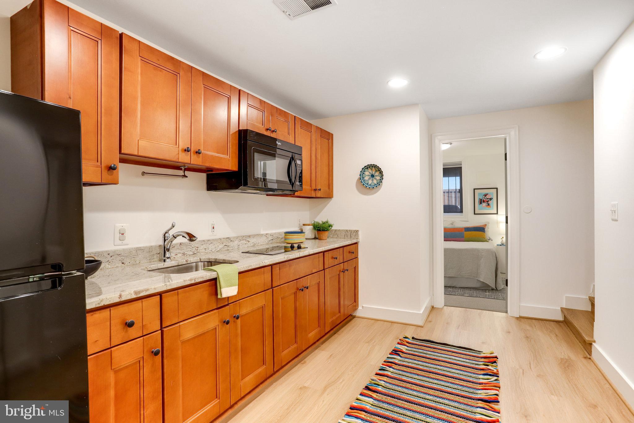 1304 E Street Northeast Washington, DC 20002 - Photo 29 of 42 a kitchen with stainless steel appliances granite countertop a sink stove and refrigerator