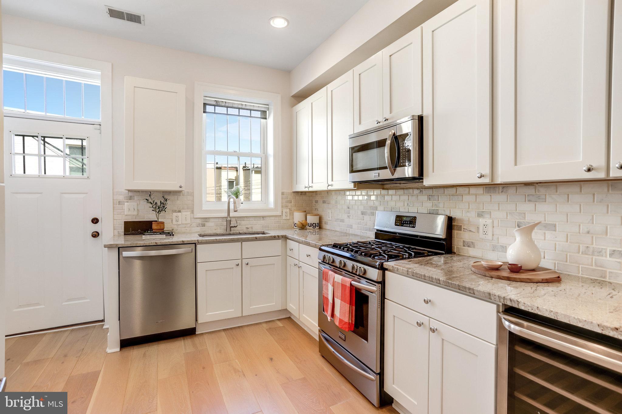 1304 E Street Northeast Washington, DC 20002 - Photo 10 of 42 a kitchen with granite countertop cabinets stainless steel appliances and a sink