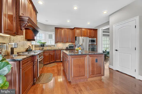 a kitchen with stainless steel appliances granite countertop a stove a sink dishwasher and a refrigerator