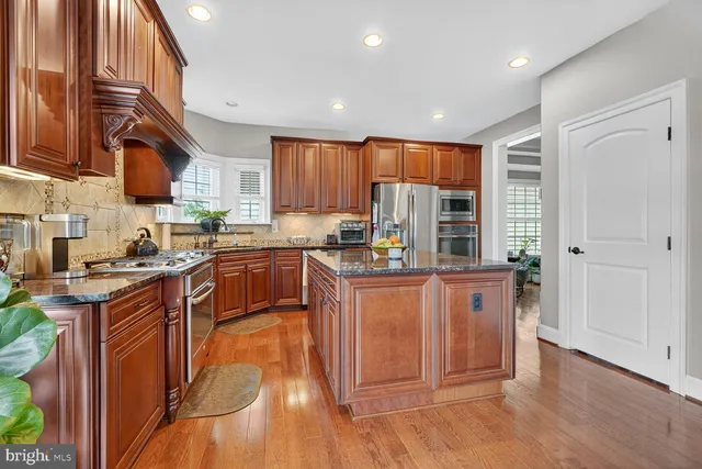 a kitchen with stainless steel appliances granite countertop a stove a sink dishwasher and a refrigerator