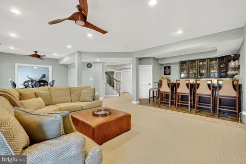 a living room with furniture a ceiling fan and a window