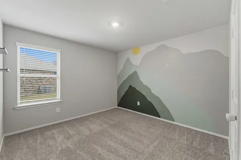 a view of an empty room with a window and a kitchen