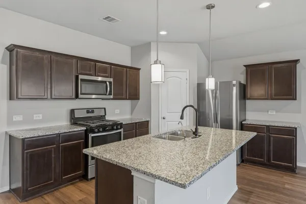 a kitchen with stainless steel appliances granite countertop a sink stove and refrigerator
