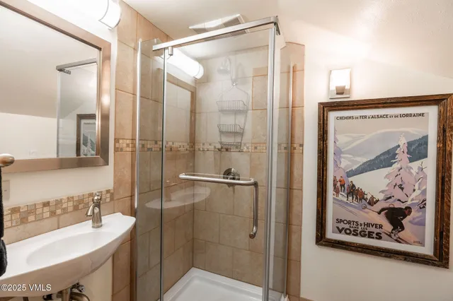 a bathroom with a shower sink and mirror