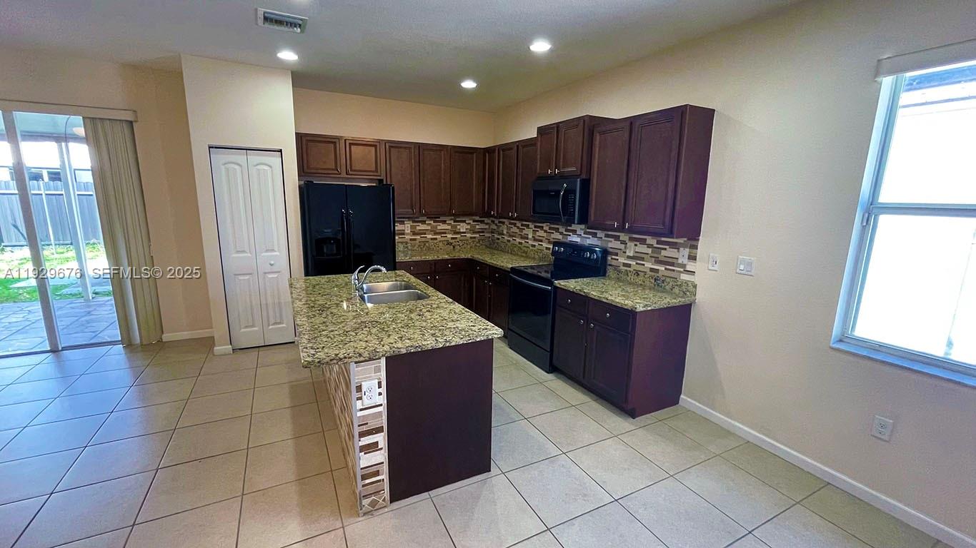22912 Southwest 115th Court Miami, FL 33170 - Photo 11 of 29 a kitchen with stainless steel appliances granite countertop a stove and a refrigerator