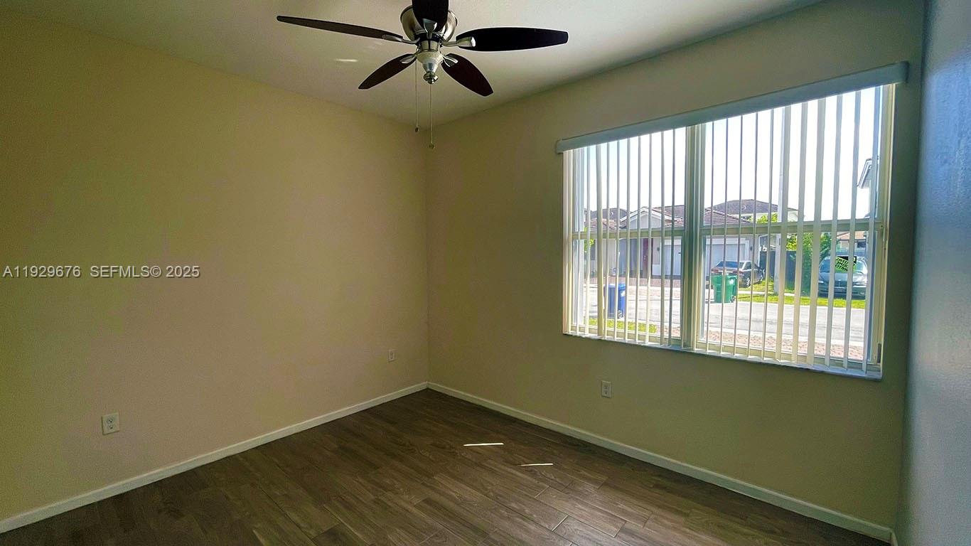 22912 Southwest 115th Court Miami, FL 33170 - Photo 17 of 29 a view of empty room with wooden floor and fan
