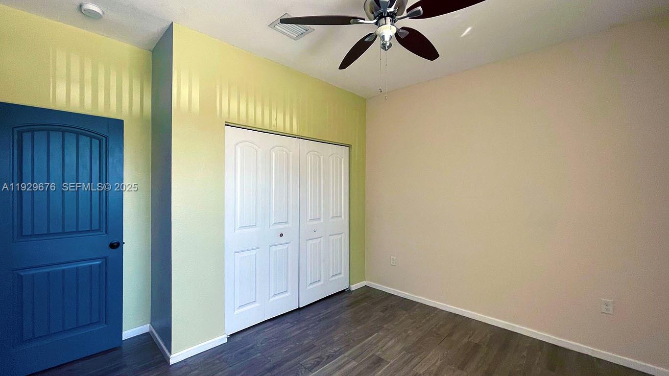 22912 Southwest 115th Court Miami, FL 33170 - Photo 18 of 29 an empty room with wooden floor closet and windows