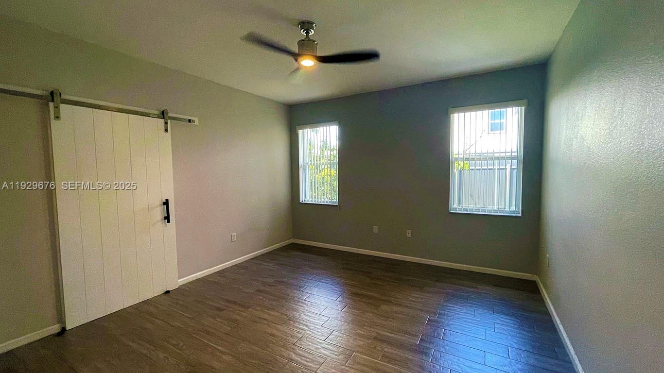 22912 Southwest 115th Court Miami, FL 33170 - Photo 22 of 29 an empty room with wooden floor a ceiling fan and closet