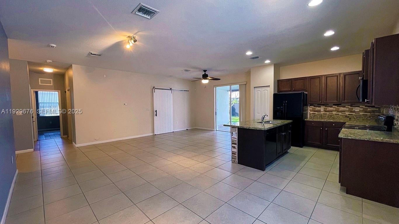 22912 Southwest 115th Court Miami, FL 33170 - Photo 7 of 29 a large kitchen with stainless steel appliances kitchen island granite countertop a refrigerator and a sink