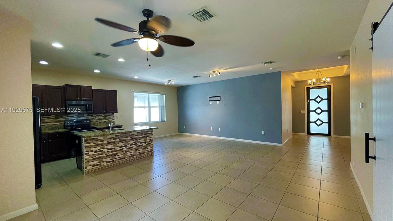 22912 Southwest 115th Court Miami, FL 33170 - Photo 9 of 29 a kitchen with stainless steel appliances granite countertop a stove and a refrigerator