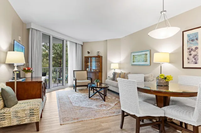 a kitchen with stainless steel appliances kitchen island granite countertop a table chairs in it and a window